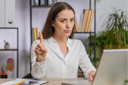 Person holding up finger as a warning and advising not to make mistakes